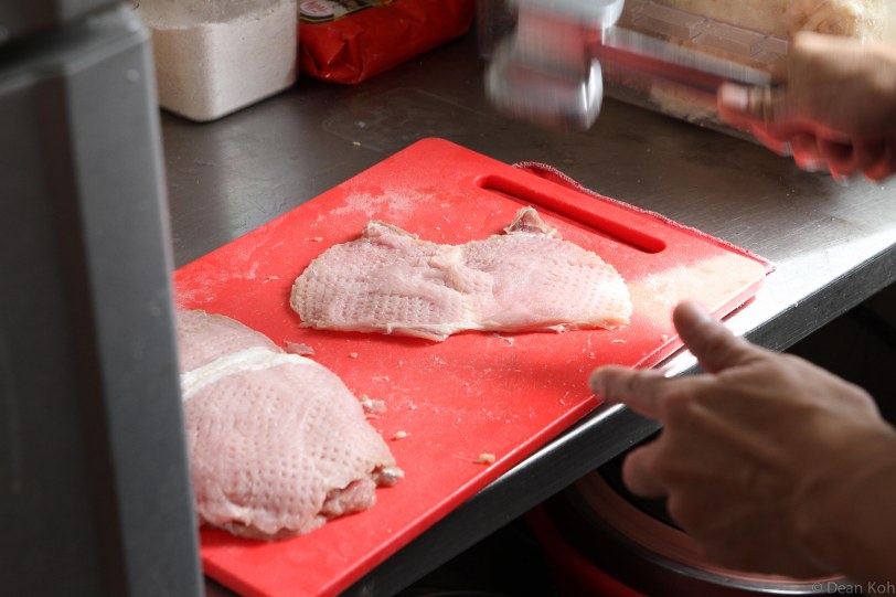 Sliced pork loins are being 'hammered' to make them more tender and easier to cook...